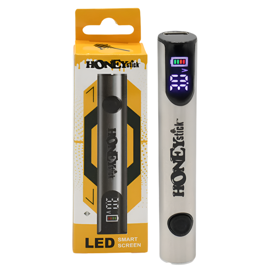 A HoneyStick Digital 510 Variable Voltage Battery in silver, displayed next to its packaging. The battery features an LED smart screen that shows voltage settings and battery life.