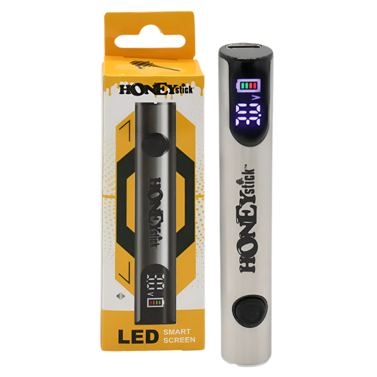 A HoneyStick Digital 510 Variable Voltage Battery in silver, displayed next to its packaging. The battery features an LED smart screen that shows voltage settings and battery life.